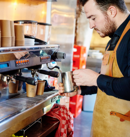 Barista die melk opschuimt