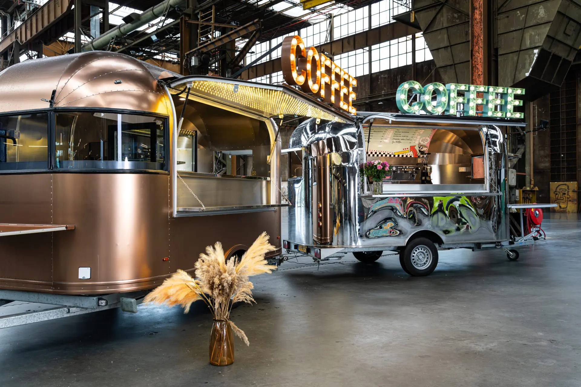 Koffietruck van brons en chroom in een industriële hal