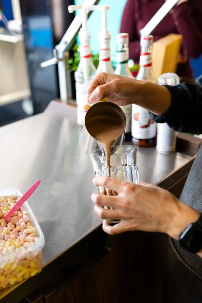Barista bereidt een koude koffiespecialiteit met topping